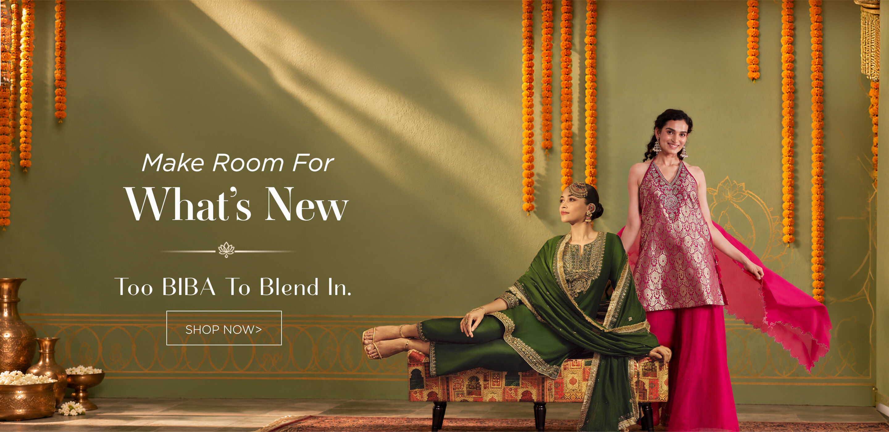 Two women wearing richly colored BIBA Indian occasion wear